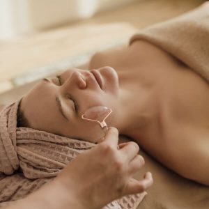 O femeie care primește servicii spa cu un masaj facial.