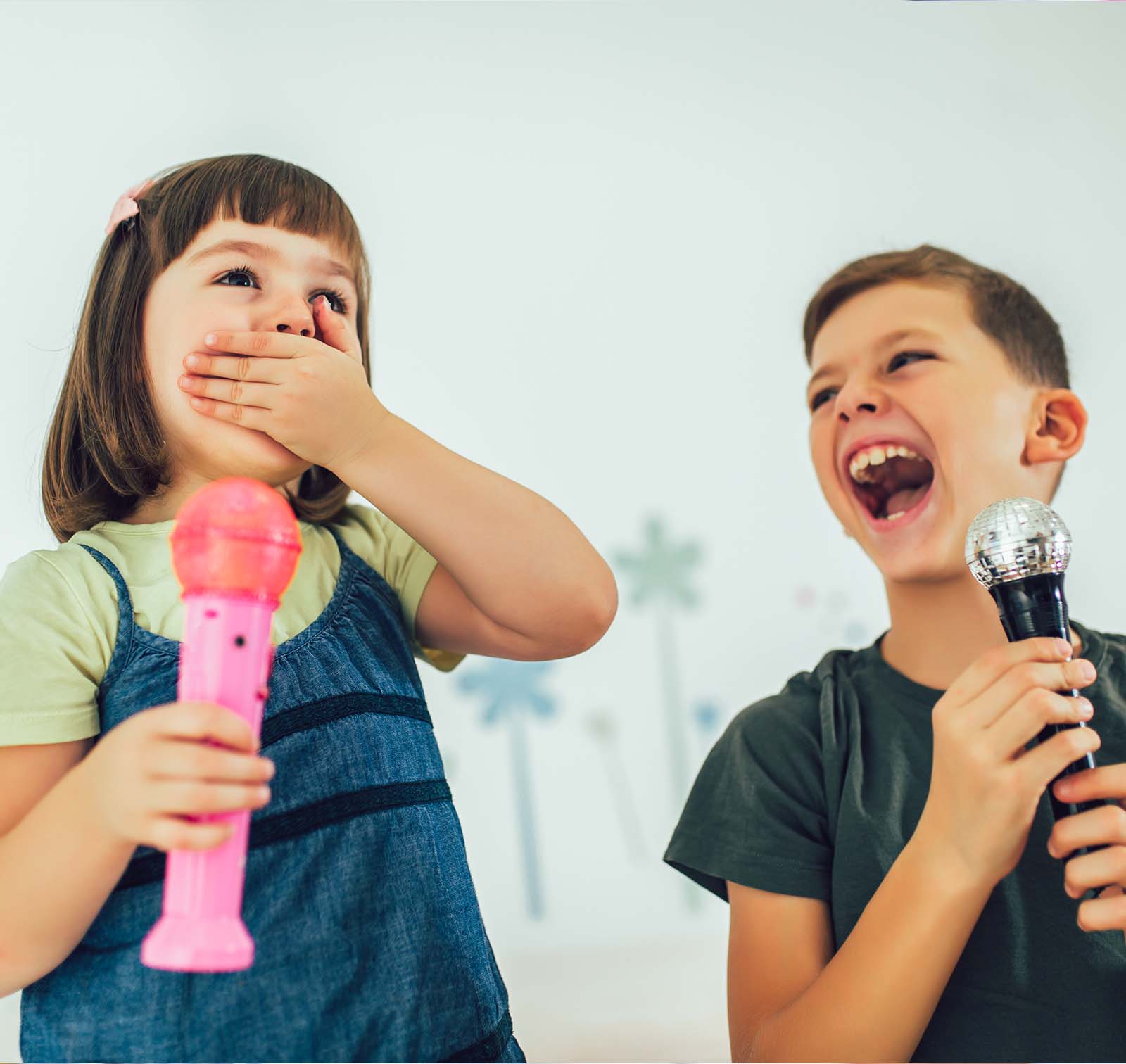 Un băiat și o fată ținând microfoane în timpul cursurilor de Public Speaking.