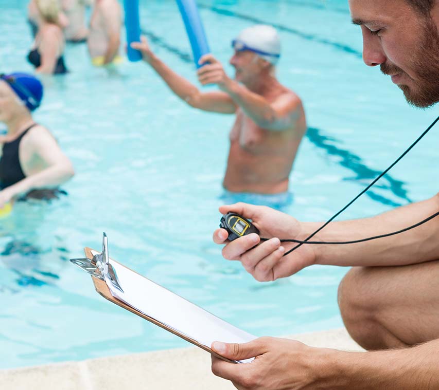 Un bărbat care ține un clipboard într-o piscină în timp ce discută despre terapia sonoră pentru îmbunătățirea sănătății și a bunăstării.